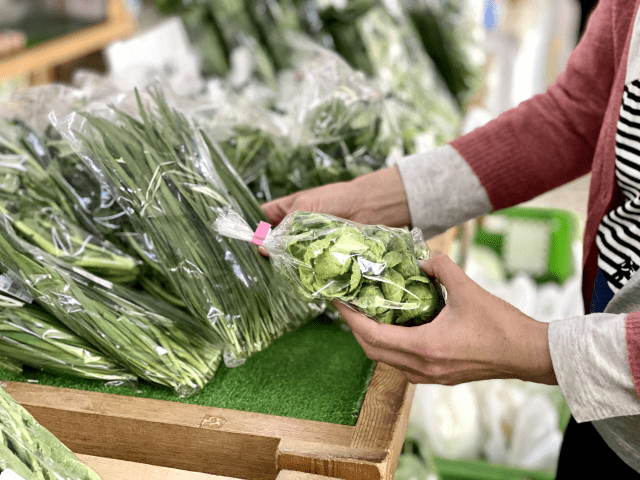 地域の直売所で野菜を手に取る様子